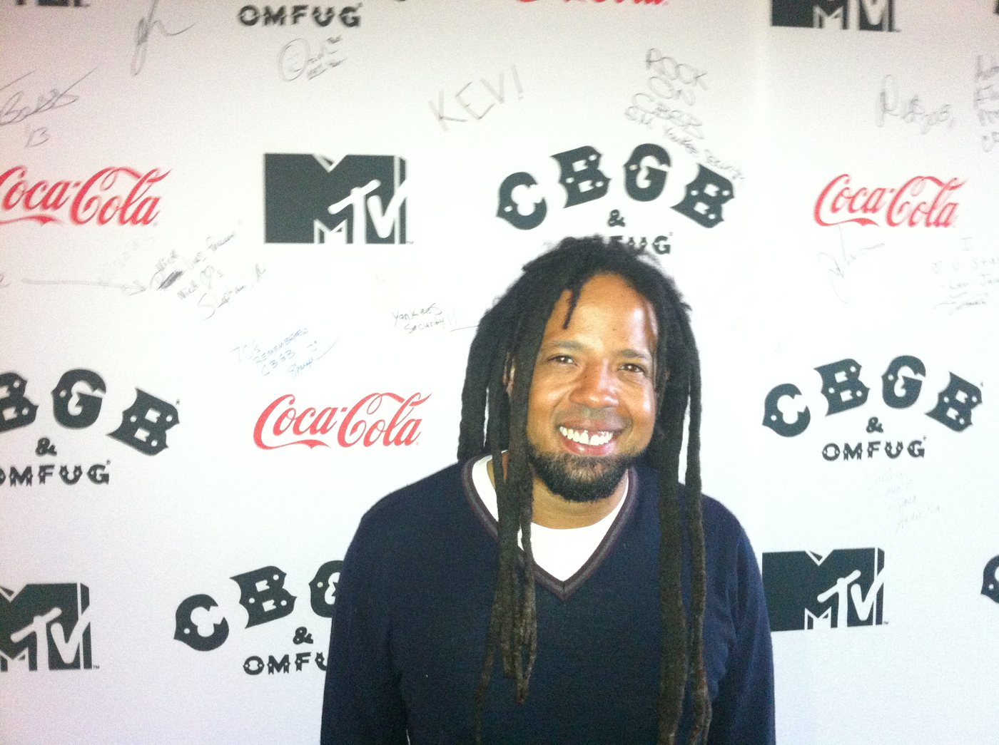 Barry Cole smiling in front of a CBGB & OMFUG and MTV event backdrop